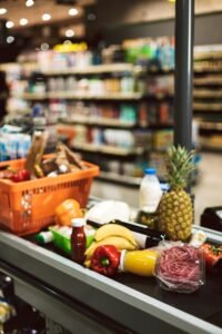 Close up shopping basket and products on cashier desk in superma